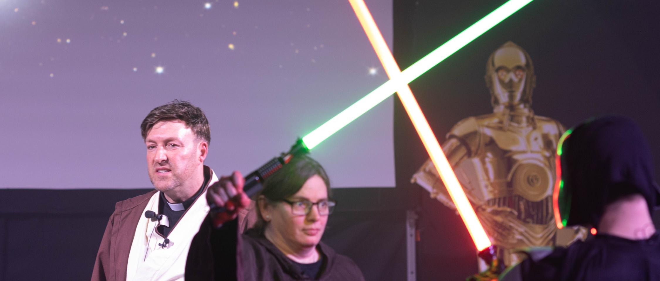 Jugendpfarrer Gerd Richard Neumeier und Anja Baumer-Löw, die mit Darth Vader Lichtschwerter kreuzt