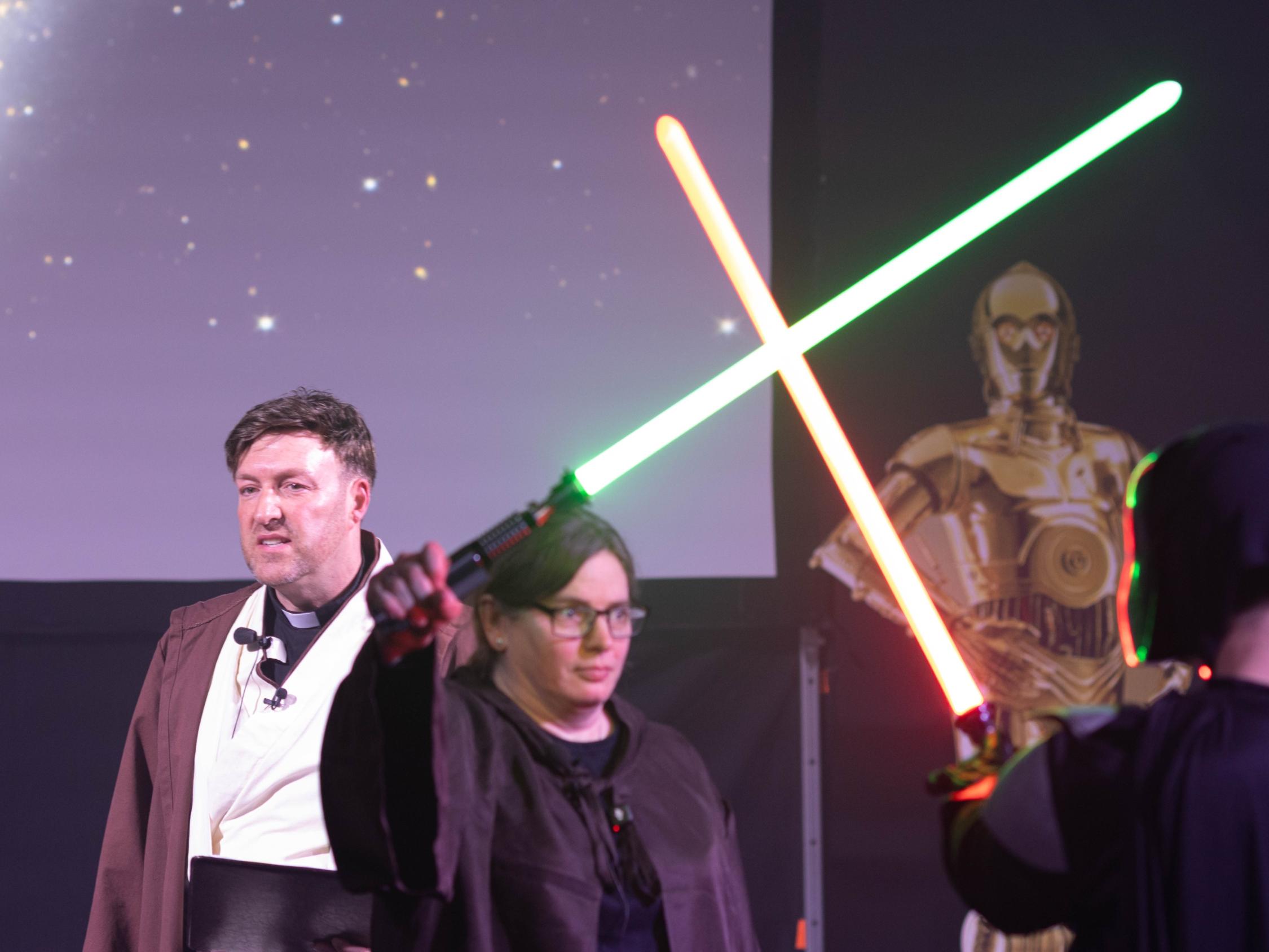 Jugendpfarrer Gerd Richard Neumeier und Anja Baumer-Löw, die mit Darth Vader Lichtschwerter kreuzt