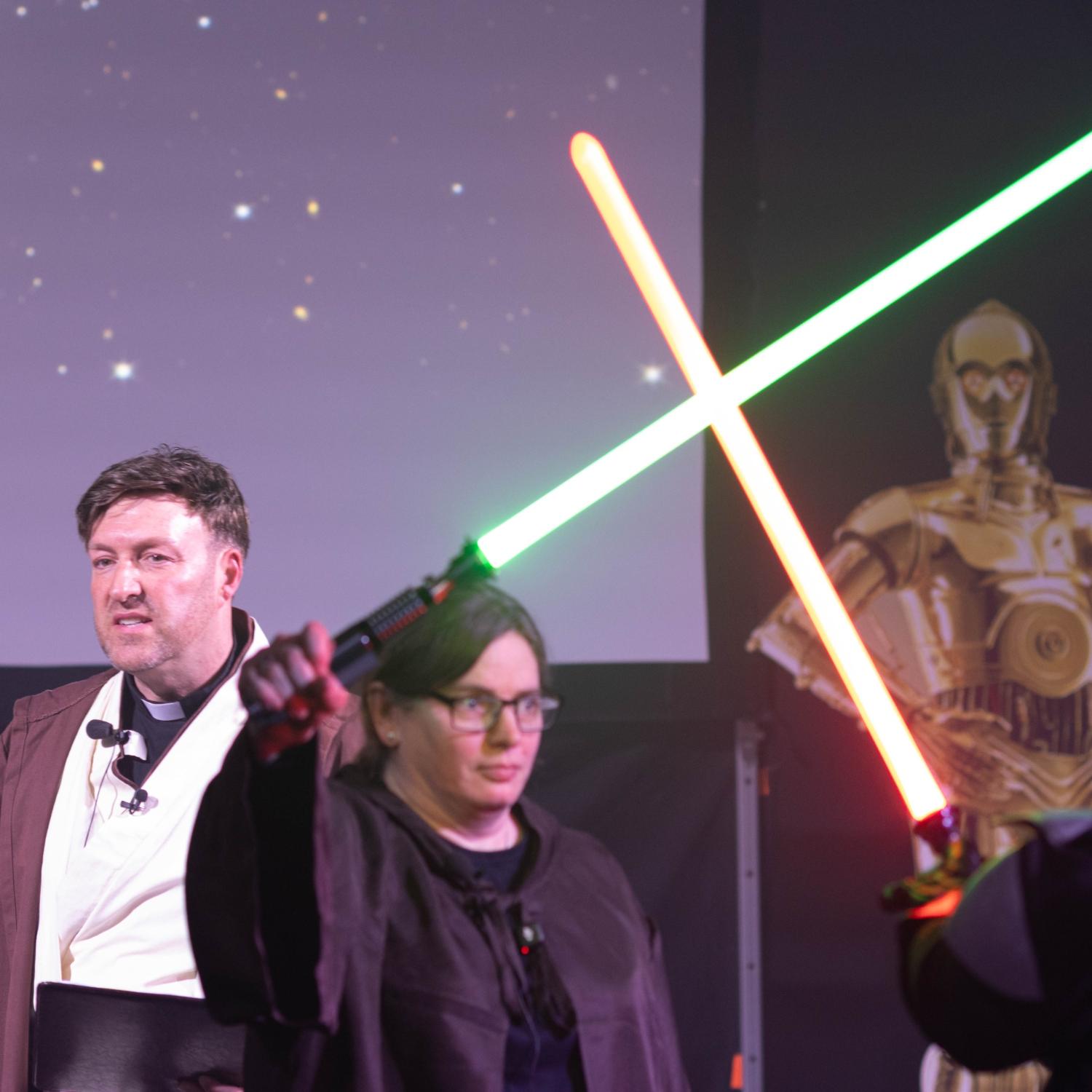 Jugendpfarrer Gerd Richard Neumeier und Anja Baumer-Löw, die mit Darth Vader Lichtschwerter kreuzt