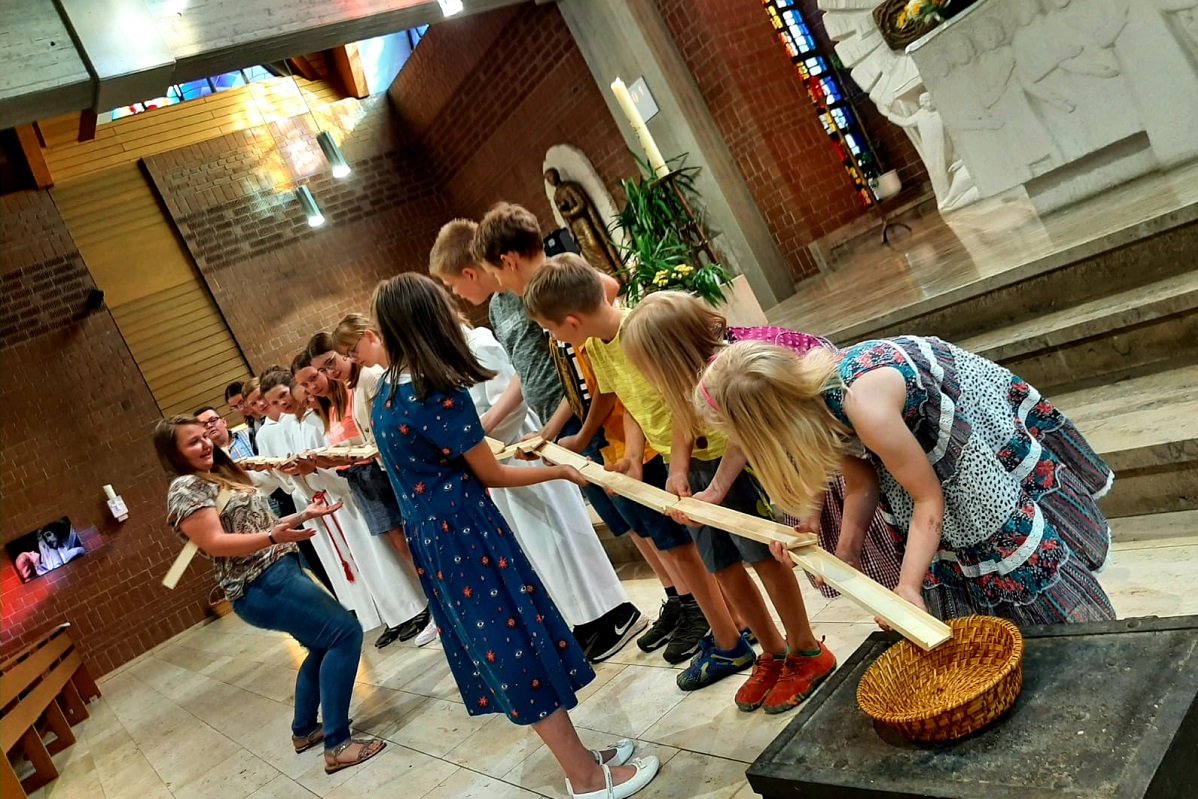 Besucher des Jugendgottesdienstes bauen zusammen eine Murmelbahn.