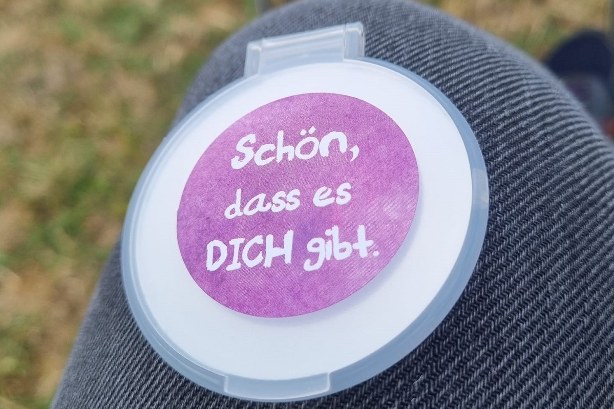 Ein Handspiegel mit dem Aufdruck 'Schön, dass es dich gibt'.