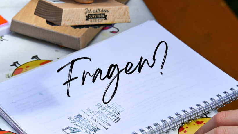 'Fragen?' auf einem Notizblock