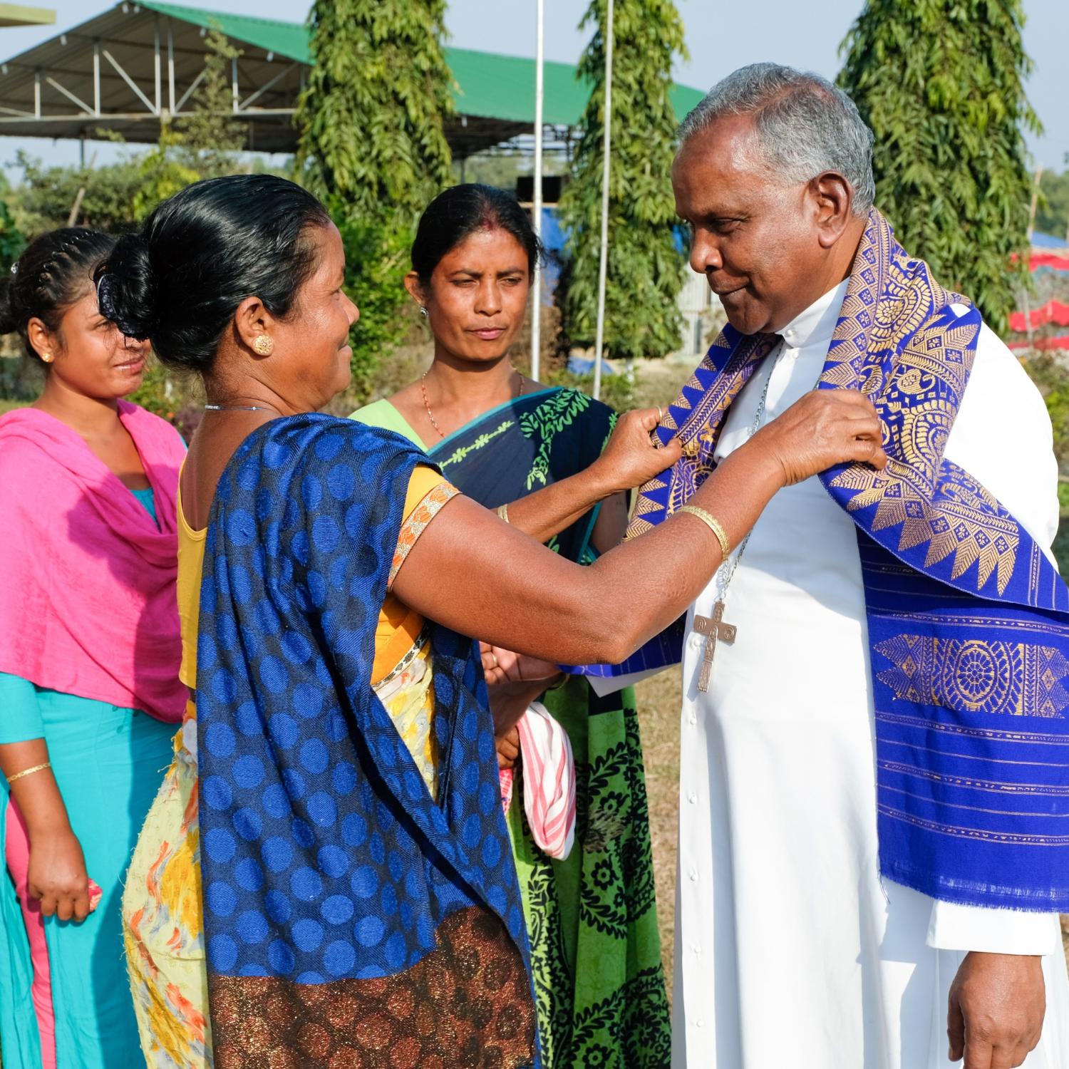 In Assam begrüßt die Gemeinde Bischof Michael Akasius Toppo mit einem Schal.