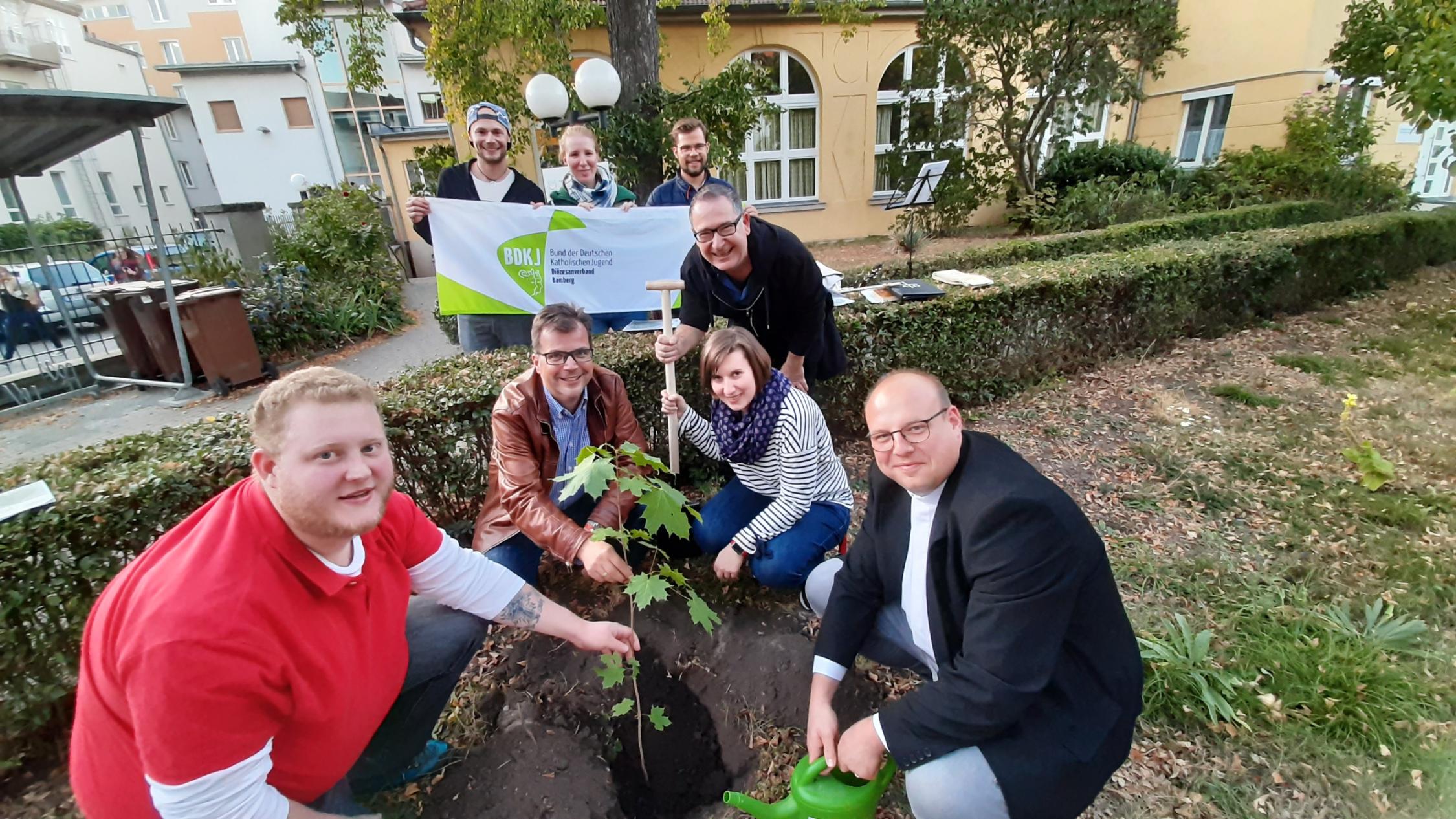Jugendliche des BDKJ pflanzen zusammen mit dem Diözesanvorstand und Bambergs Zweitem Bürgermeister Christian Lange einen Spitzahorn im Garten des Jugendamtes der Erzdiözese.