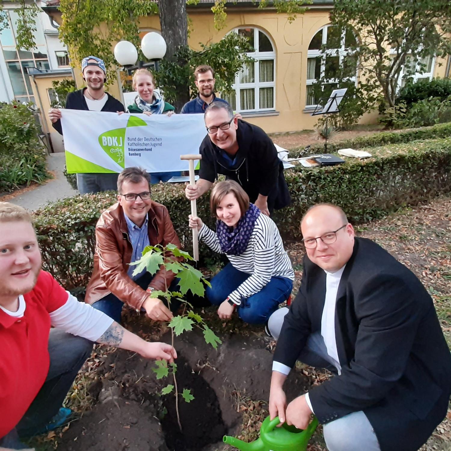 Jugendliche des BDKJ pflanzen zusammen mit dem Diözesanvorstand und Bambergs Zweitem Bürgermeister Christian Lange einen Spitzahorn im Garten des Jugendamtes der Erzdiözese.