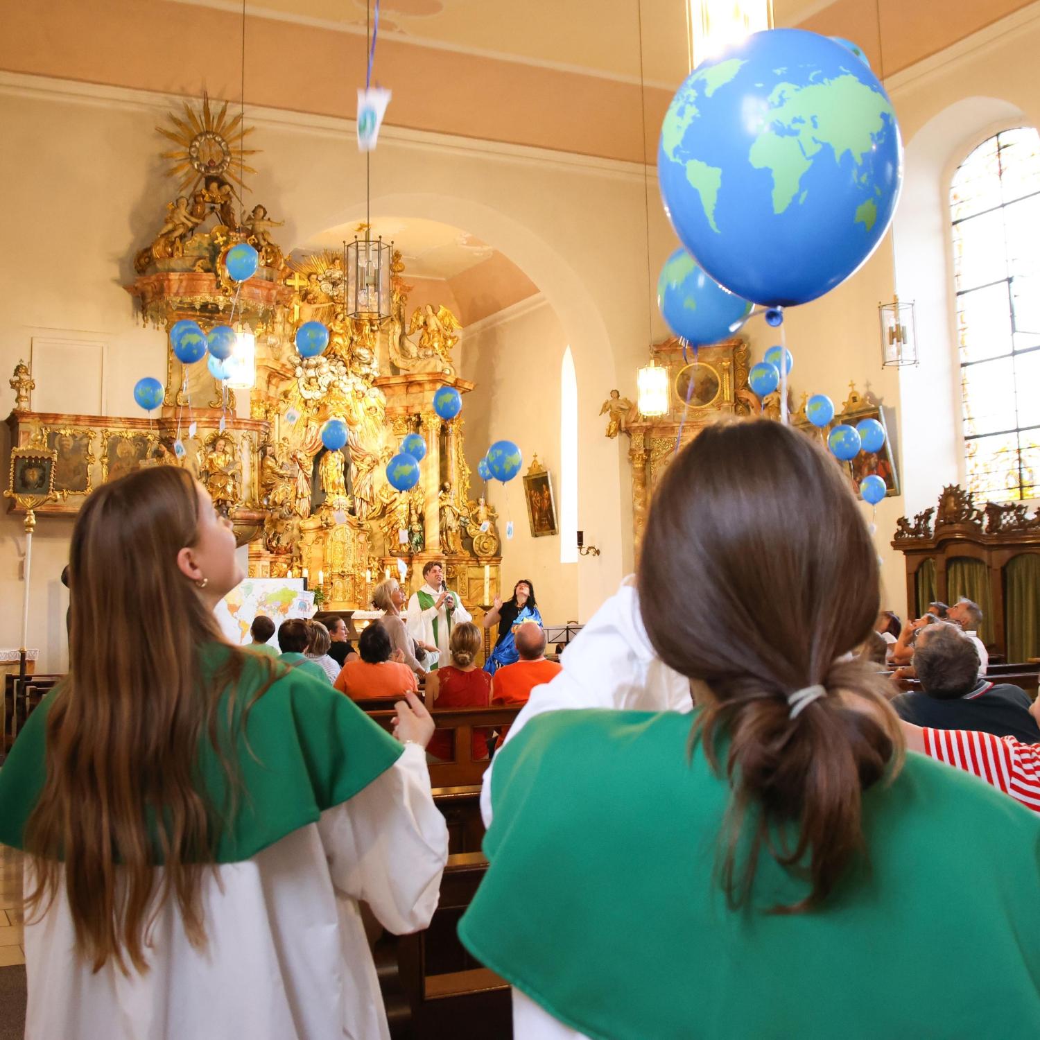Luftballons steigen zur Kirchendecke hinauf.