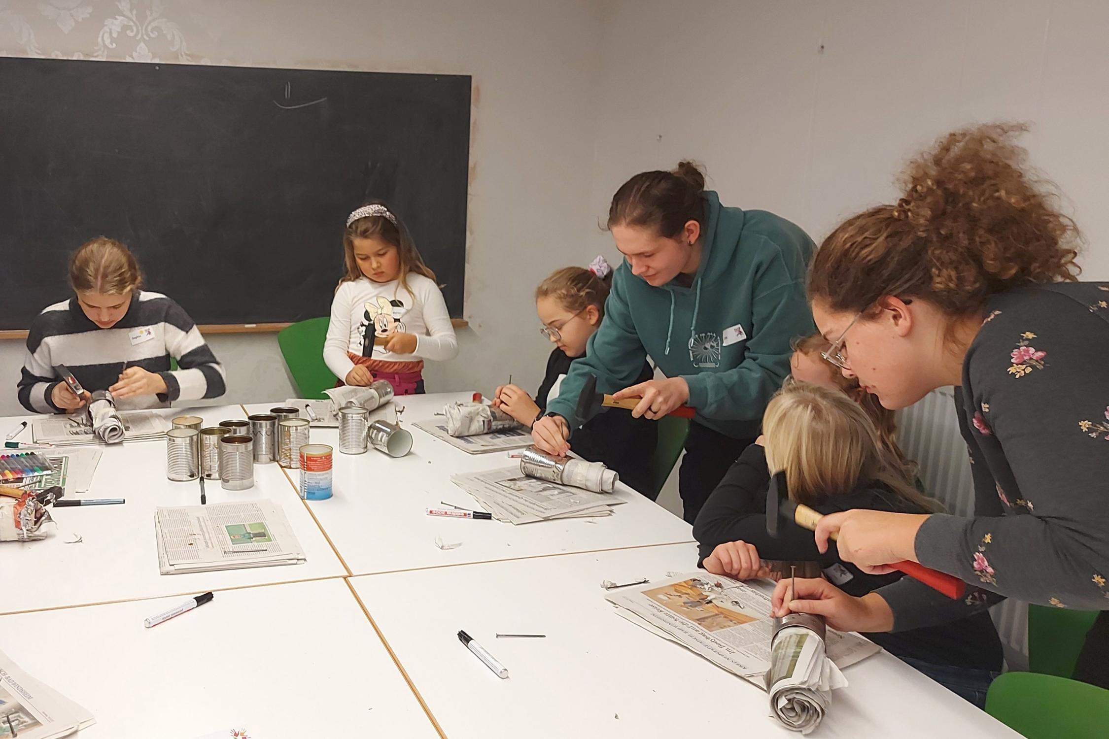Workshop „Für Martin leuchten“ – gar nicht so einfach, Löcher in die Dosen zu klopfen.